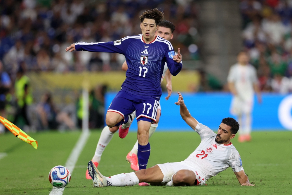 Tunisia's defender #21 Mohamed Ben Hamida kicks the ball out of the sidelines as Japan's forward #17 Yuito Suzuki jumps during the 2026 World Cup Group F football match between Tunisia and Japan at the Monterrey Stadium in Guadalupe, Mexico, on June 20, 2026. (Photo by Julio Cesar Aguilar / AFP)