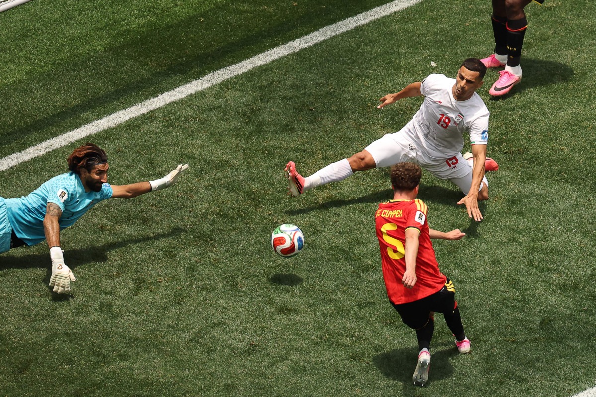 Iran's goalkeeper #01 Alireza Beiranvand makes a save past Belgium's defender #05 Maxim De Cuyper during the 2026 World Cup Group G football match between Belgium and Iran at the Los Angeles Stadium in Inglewood on June 21, 2026. (Photo by Etienne Laurent / AFP)