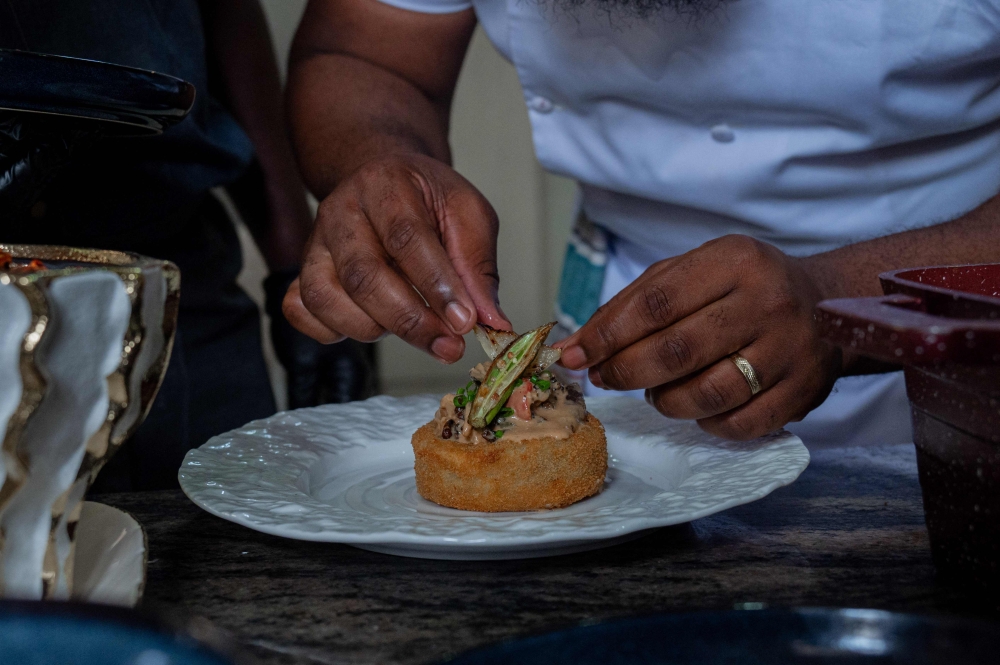 Congolese chef Archi Dimosi plates one of his signature dishes in Kinshasa on May 17, 2026. (Photo by Hardy Bope / AFP)