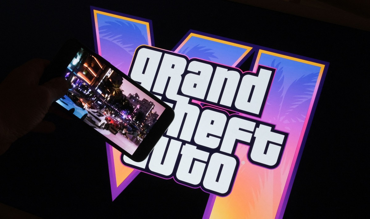 This illustration photo created in Los Angeles, December 4, 2023, shows Rockstar Games’ Grand Theft Auto VI trailer played on a screen in front of the game title. Photo by Chris DELMAS / AFP