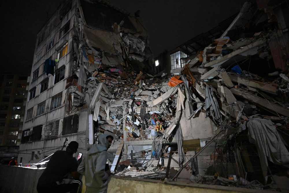 People look at a collapsed building in the Altamira neighbourhood following an earthquake in Caracas on June 24, 2026. (Photo by Federico PARRA / AFP)
 