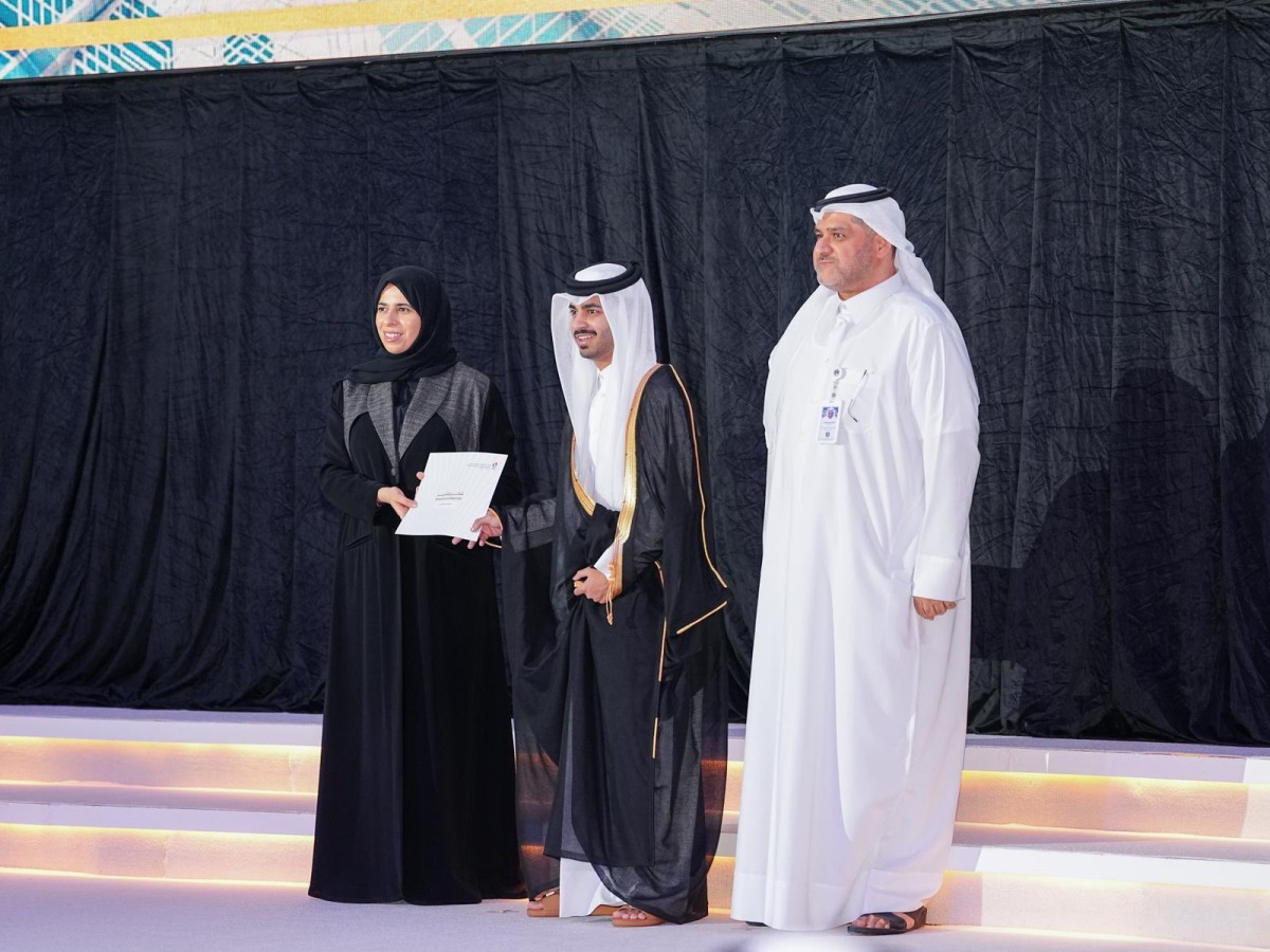 Minister of Education and Higher Education H E Lolwah bint Rashid bin Mohammed Al Khater honouring a graduate of Qatar School for Science and Technology for Boys during a ceremony.