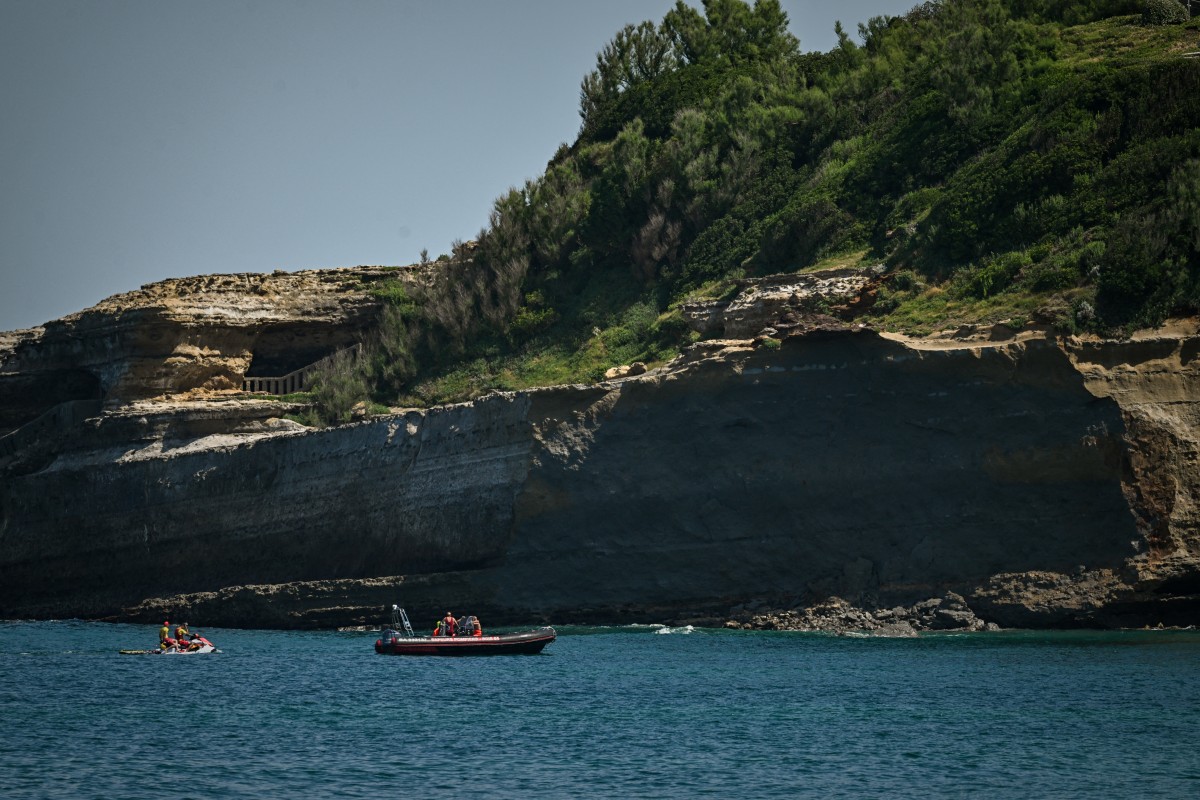 Firefighters search by boat at the base of the cliff from which a section collapsed near Miramar beach, killing one woman and leaving a diver missing, in Biarritz, south-western France, on June 25, 2026. Photo by PHILIPPE LOPEZ / AFP
