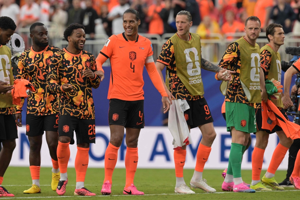 From L: Netherlands' midfielder #26 Quinten Timber, defender #04 Virgil van Dijk and forward #09 Wout Weghorst celebrate after winning the 2026 World Cup Group F football match between Tunisia and the Netherlands. (Photo by Juan Mabromata / AFP)