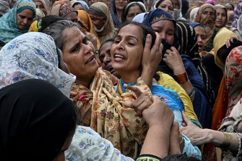 Relatives mourn the deceased children before their burial in Lahore on July 1, 2026, after the roof of a tutoring centre collapsed the previous day. Photo by Arif Ali / AFP