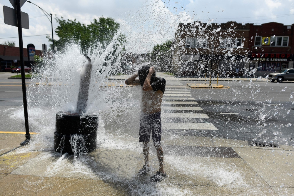 A person cools off with water from an open fire hydrant during a heat wave on the West Side of Chicago, Illinois, on July 2, 2026. (Photo by Octavio Jones / AFP)
