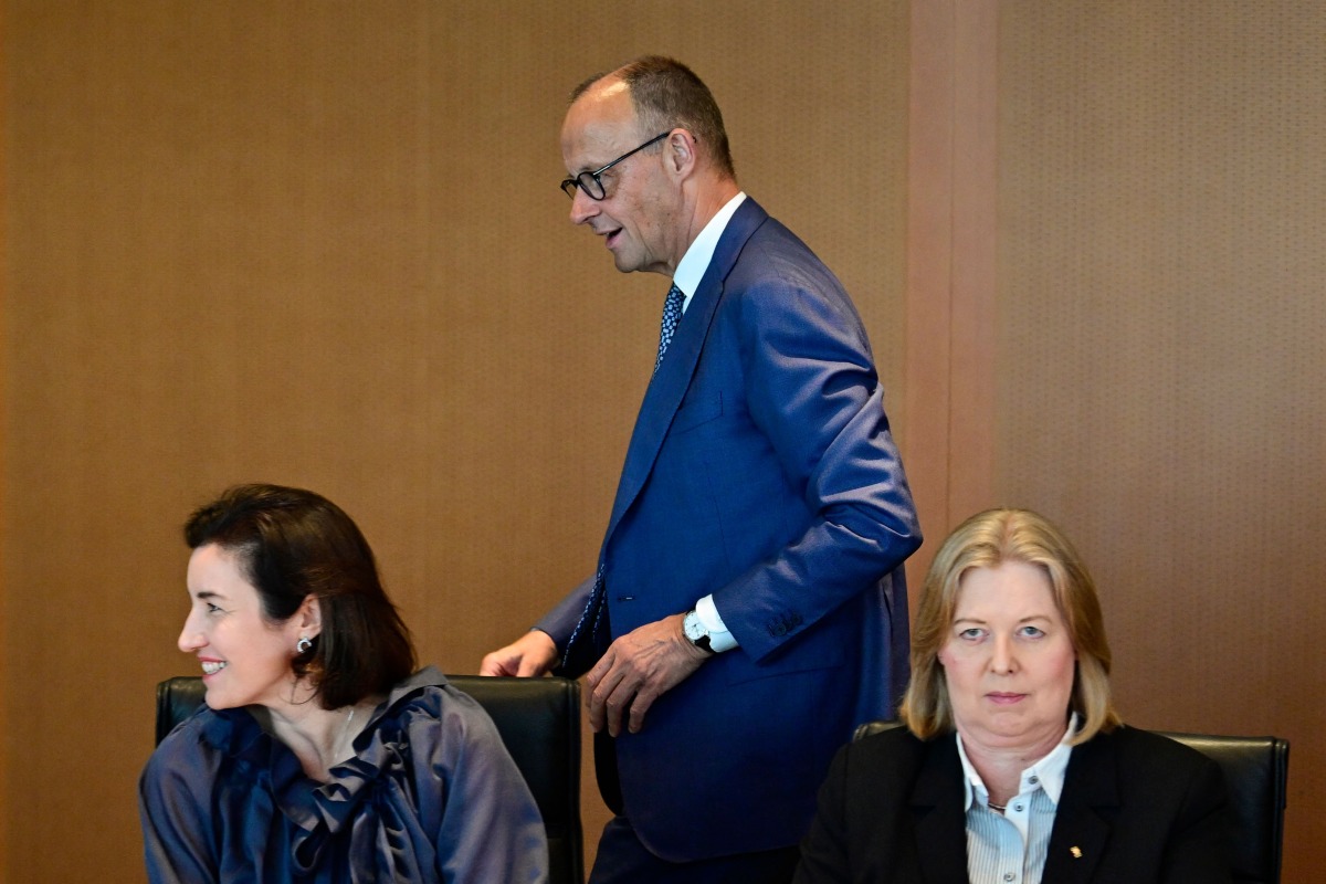 German Chancellor Friedrich Merz walks past German Minister for Research, Technology and Aerospace Dorothee Baer (front L) and German Minister for Labour and Social Affairs Baerbel Bas prior to the weekly cabinet meeting at the Chancellery in Berlin, Germany, on July 6, 2026. (Photo by John MACDOUGALL / AFP)