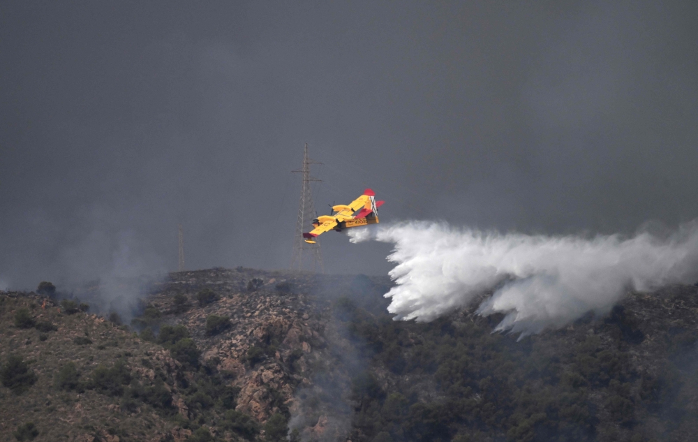 A picture taken on July 10, 2026 shows a Canadair water bombing aircraft on the site of a wildfire that killed 11 near Los Gallardos, in Almeria Province. (Photo by Jose Jordan / AFP)
