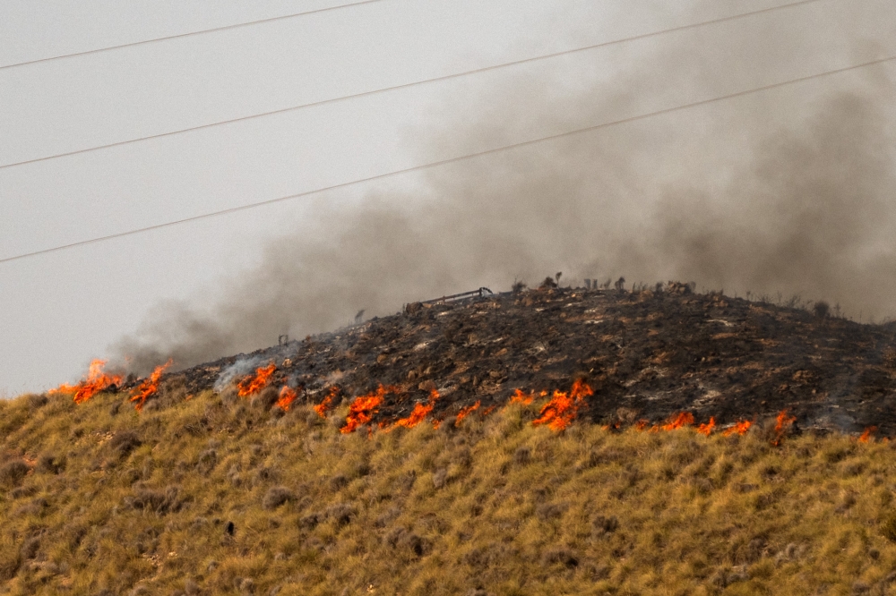 Flames stretching along a hillside are pictured in the area of a wildfire that killed at least 12 people near Bedar, in Los Gallardos district, in Almeria Province, on July 11, 2026.  (Photo by JORGE GUERRERO / AFP)