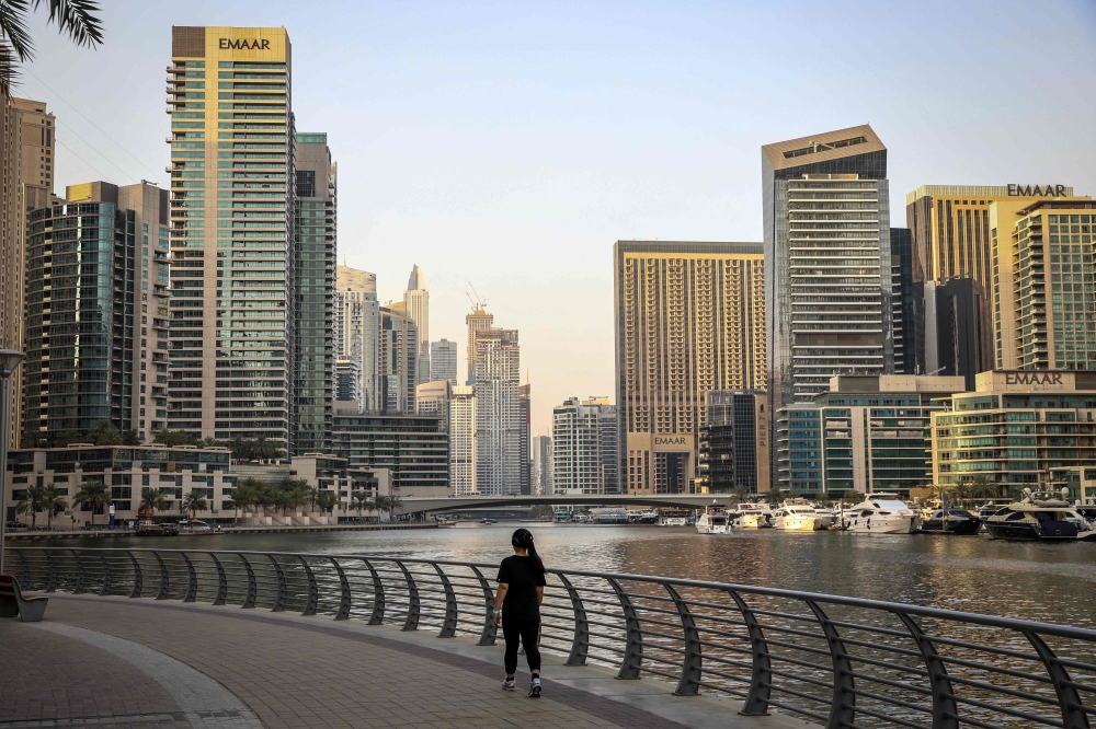 A woman walks through Dubai's Marina district on July 21, 2026. (Photo by Fadel Senna / AFP)