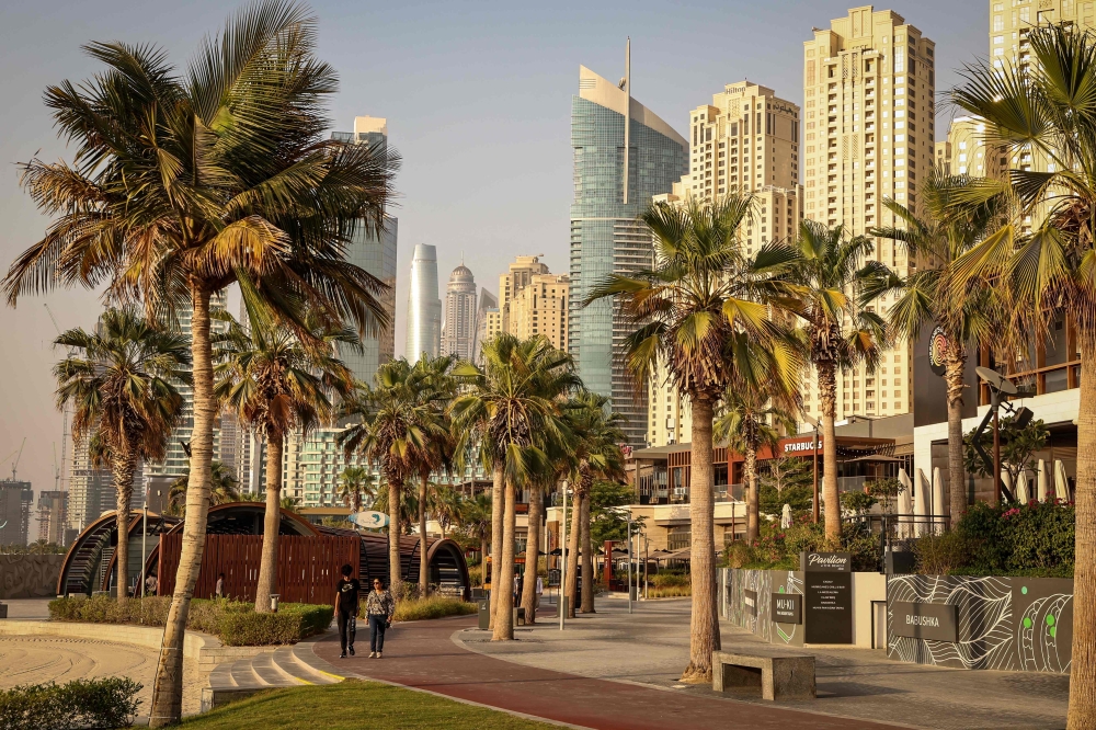 People walk through the Jumeirah Beach Residence (JBR) district in Dubai on July 21, 2026. (Photo by Fadel Senna / AFP)  