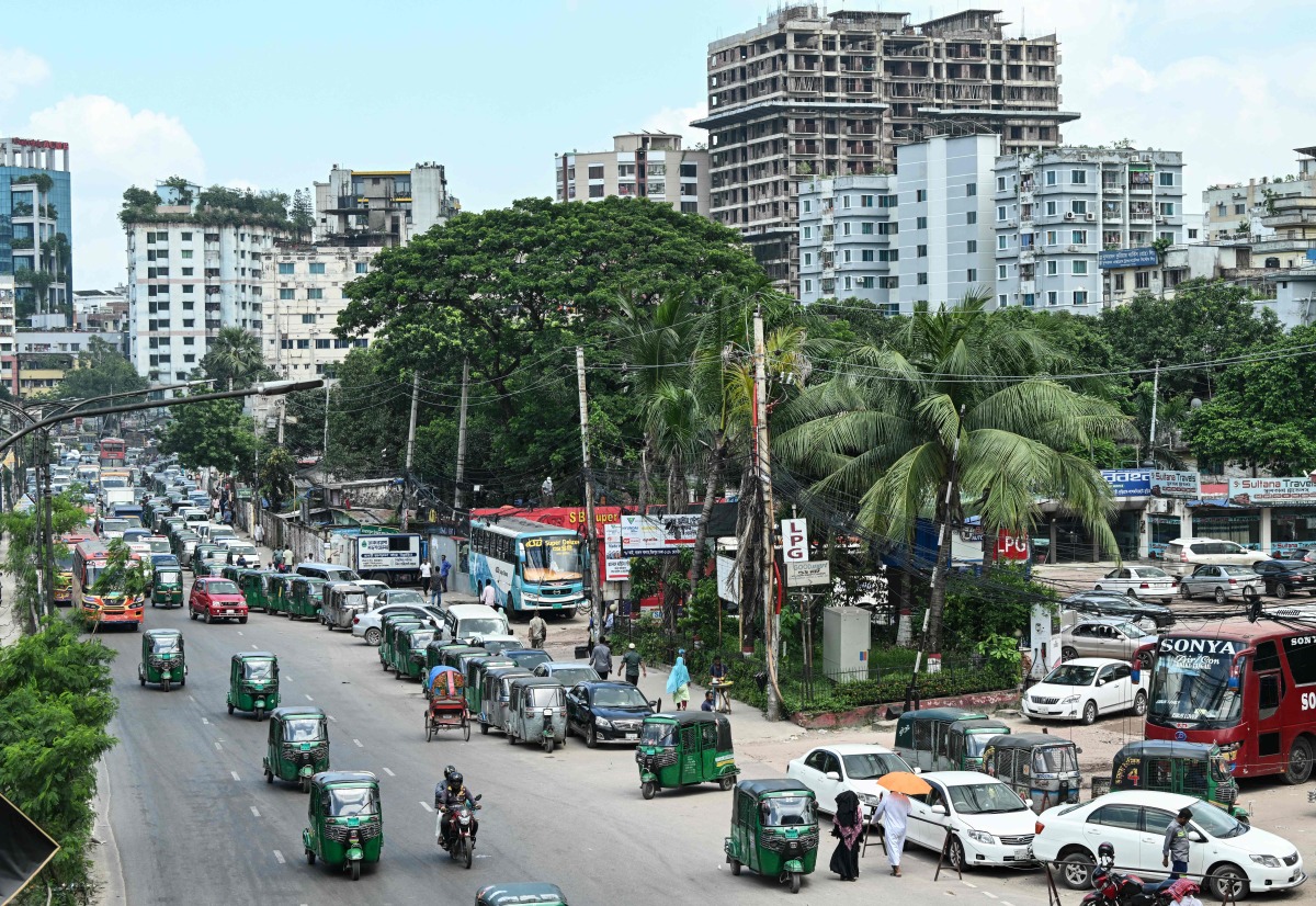 Vehicles wait in a queue to refuel with compressed natural gas (CNG) at a filling station in Dhaka on July 26, 2026. (Photo by MUNIR UZ ZAMAN / AFP)
