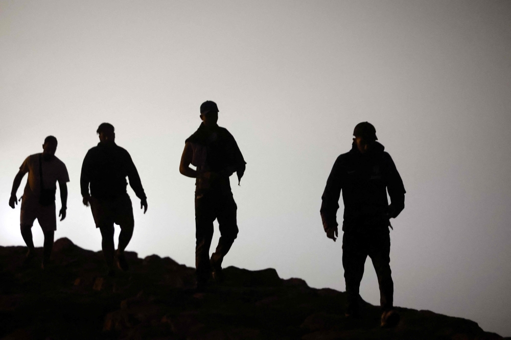 Migrants walk towards the Fnideq region in northern Morocco after leaving Spain's North African enclave of Ceuta near the town of Fnideq, on the Morocco-Spain border, following an attempted to cross at the Bab Sebta border crossing, on the Morocco- (Photo by Abdel Majid BZIOUAT / AFP)