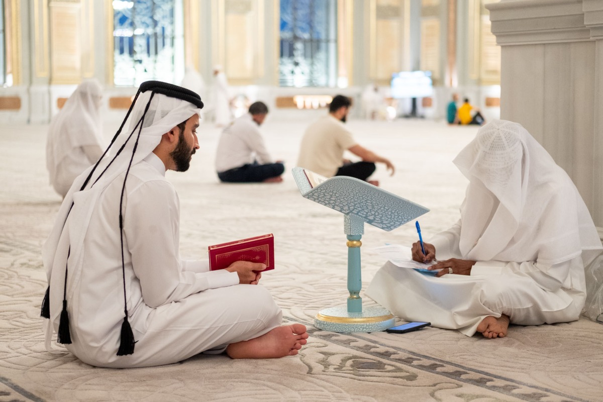 A participant with a teacher during a session of the Quran recitation programme.