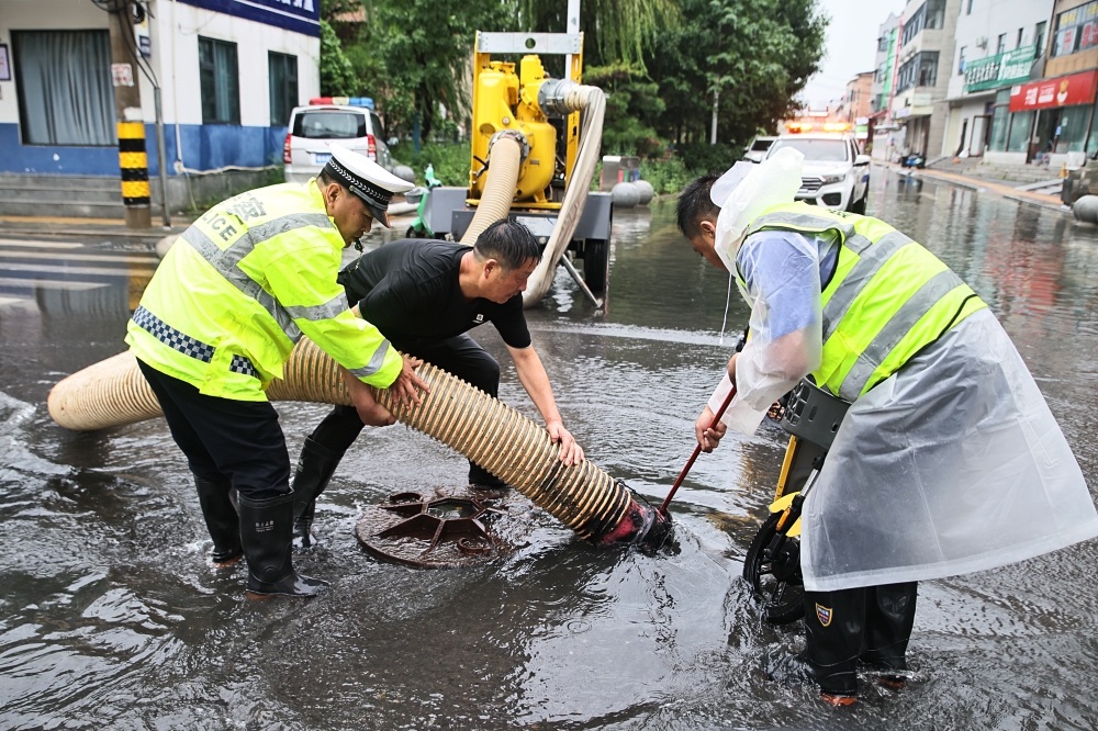 Staff members drain flood water from a water-logged road in Weishi County of Kaifeng, central China's Henan Province, Aug. 11, 2026. (Photo by Li Xinyi/Xinhua)