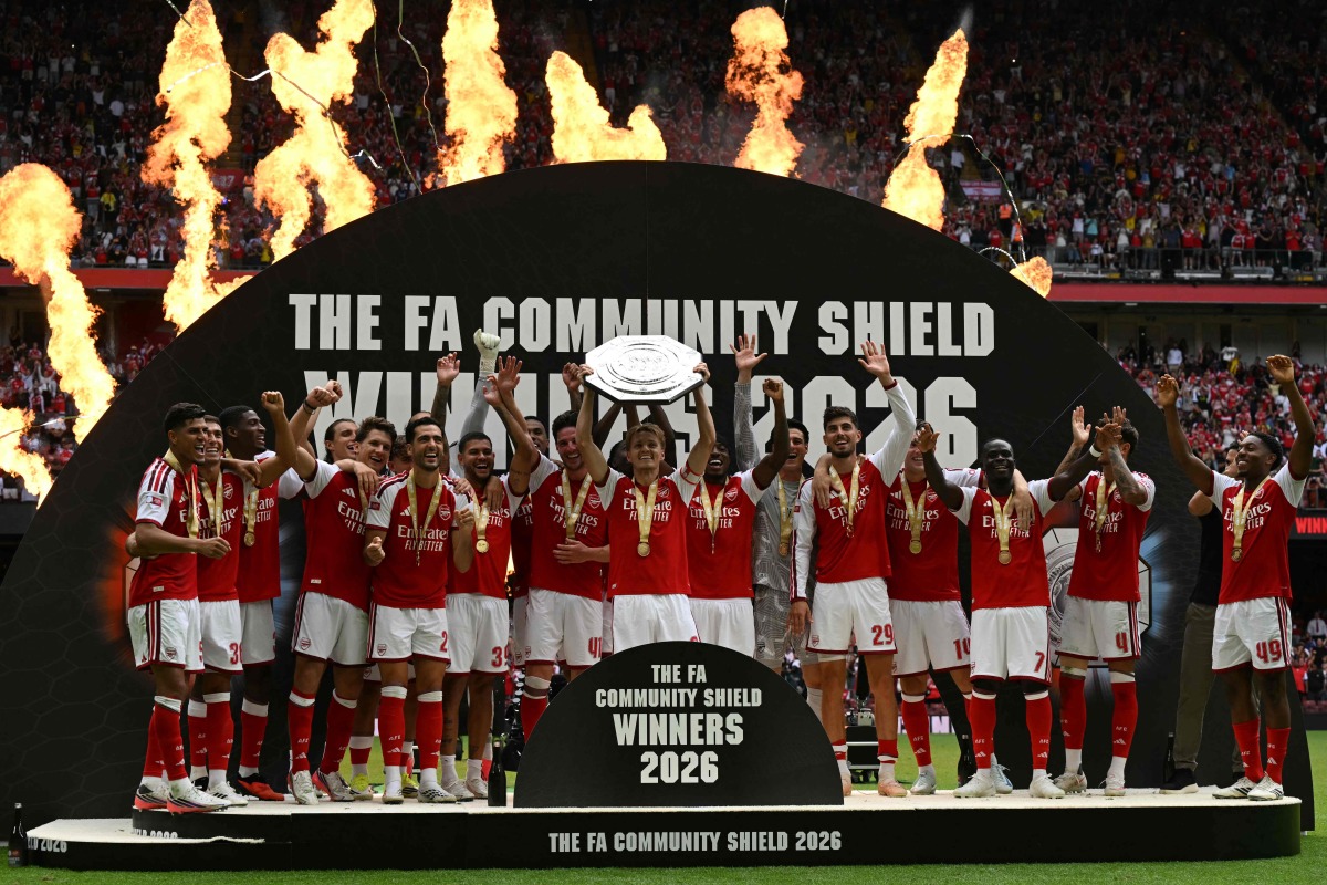 Arsenal's Norwegian midfielder #08 Martin Odegaard lifts the trophy as Arsenal's players celebrate their victory after the English FA Community Shield football match between Arsenal and Manchester City at The Principality Stadium, in Cardiff, south Wales on August 16, 2026. Arsenal won the game 3-0. (Photo by Glyn KIRK / AFP)
