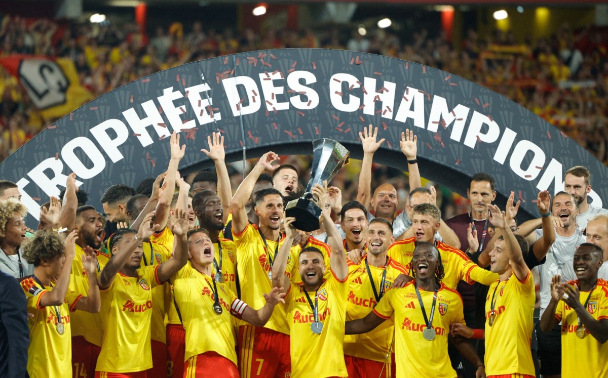Lens' players celebrate with the championship trophy after winning the French Super Cup (Trophee des Champions) football match between RC Lens and Paris Saint-Germain (PSG) at the Stade Bollaert-Delelis in Lens, northern France on August 16, 2026. (Photo by GEOFFROY VAN DER HASSELT / AFP)