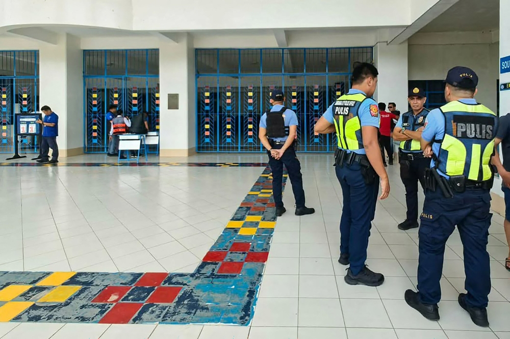 Philippine police gather at a school following a shooting in Zamboanga on August 18, 2026. A student was shot dead at a high school in the southern Philippines on August 18 before the alleged killer took his own life, police said. (Photo by Roel Parreno / AFP)