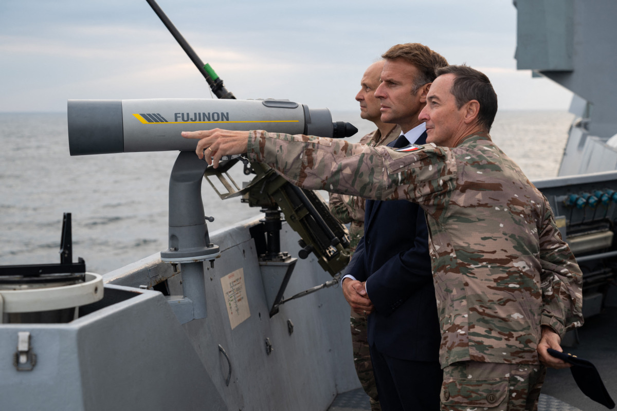 This handout photograph released and taken by the French Ministry of the Armed Forces and Veterans on October 6, 2026 shows French President Emmanuel Macron (L) attending the first test launch of a new intercontinental missile, fired from a nuclear-powered ballistic missile submarine off the coast of Finistere, western France, on October 6, 2026. (Photo by Benjamin PAPIN / French Ministry of the Armed Forces and Veterans / AFP) 