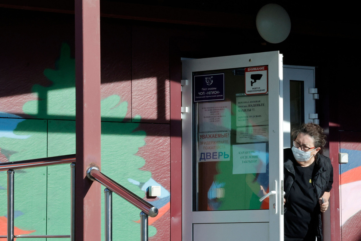 A security person wearing a face mask looks out from the door of an infectious diseases hospital in the town of Shelekhov, where an employee of the Irkutsk Antiplague Research Institute had died, in the Irkutsk region on October 7, 2026. (Photo by TATYANA MAKEYEVA / AFP)