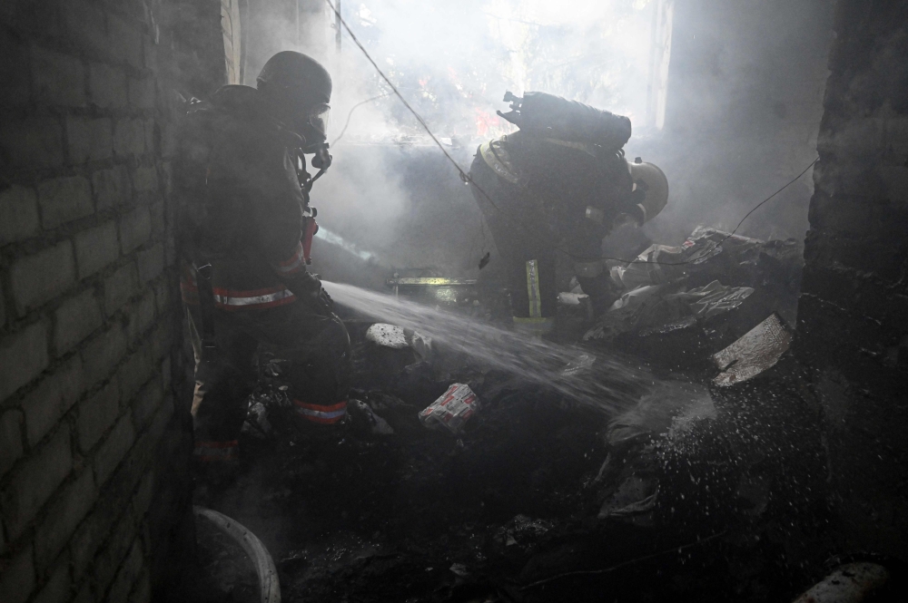 Firefighters operate to extinguish a fire inside a clinic building after a Russian aerial attack on Kharkiv on October 10, 2026. (Photo by Sergey Bobok / AFP)