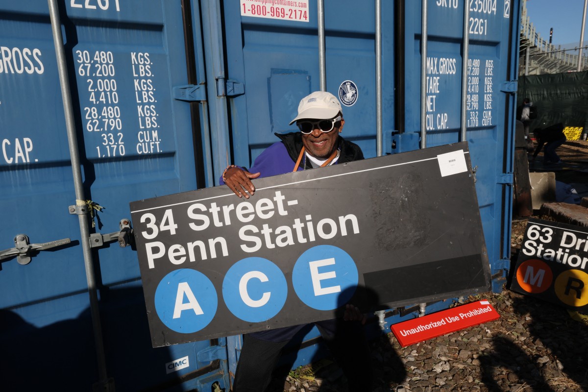 Film director Spike Lee holds a subway sign as people take home a piece of New York City's transportation system on October 9, 2026. Photos by Timothy A Clary / AFP
