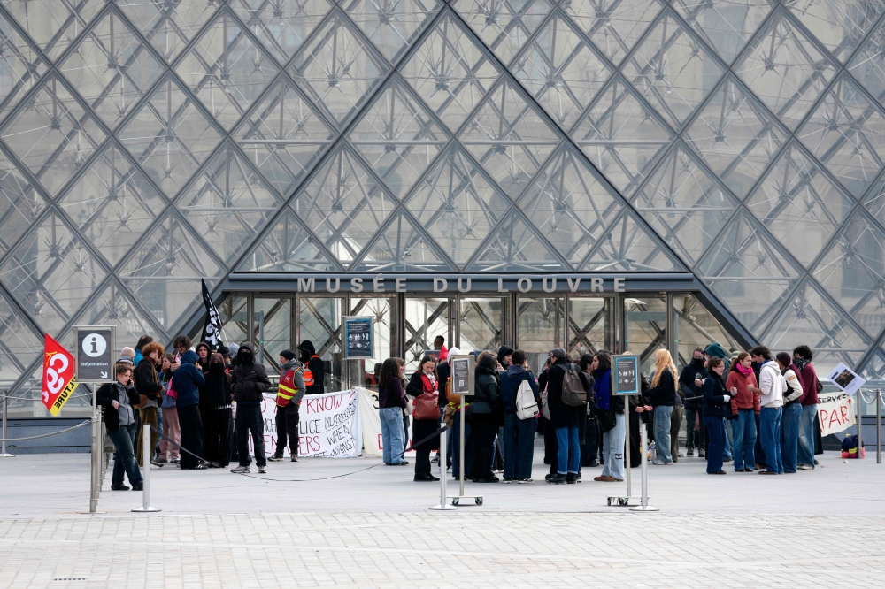 Protesters, including students from the Ecole du Louvre, block the entrance to the Louvre Museum in Paris on October 19, 2026. (Photo by Dimitar Dilkoff / AFP)