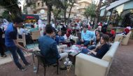 Syrian youths sits at a cafe in the government-held area of the northern Syrian city of Aleppo as they celebrate the Eid al-Adha Muslim holiday on September 13, 2016, a day after a fragile ceasefire was brokered.  AFP / Youssef KARWASHAN