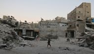 A boy walks amid damaged buildings in the rebel held area of al-Kalaseh neighbourhood of Aleppo, Syria, September 29, 2016. (Abdalrhman Ismail/Reuters)