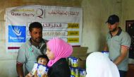 A woman receiving baby milk at a distribution centre set up by Qatar Charity in Aleppo.
