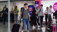 Hong Kong democracy campaigner Joshua Wong (centre L) steps into the arrivals hall at the international airport in Hong Kong on October 5, 2016, after being deported from junta-run Thailand.  / AFP / ANTHONY WALLACE