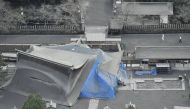 The collapsed buildings of Aso Shrine which were damaged by last April's earthquake are covered with volcanic ashes from Mount Aso in Aso, Kumamoto prefecture, southwestern Japan, in this photo taken by Kyodo October 8, 2016. Kyodo via Reuters