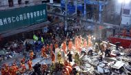 Rescuers search for survivors at an accident site after four buildings caved in during the early hours in Wenzhou, eastern China's Zhejiang province on October 10, 2016. Four people were killed when a group of houses collapsed in China on October 10, a lo