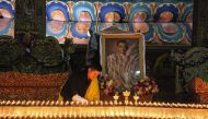 This photograph released on October 13, 2016 by Bhutan's Royal Office for Media on Bhutanese King Jigme Khesar's Facebook page shows King Jigme Khesar at the Kuenra of the Tashichhodzong in Thimpu lighting candles next to a portrait of Thailand's King Bhu