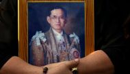 A mourner holds a portrait of Thailand's late King Bhumibol Adulyadej in Bangkok, Thailand, October 14, 2016. REUTERS/Athit Perawongmetha/File Photo.