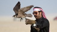 A falconer releases his falcon during a falcon contest at Qatar International Falcons and Hunting Festival at Sealine desert, Qatar. (Naseem Zeitoon / Reuters)




