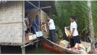 Representatives from RAF carrying food items in a boat for distribution to poor people in an Island in Indonesia.