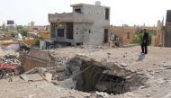 An Iraqi man stands on top of a damaged building on October 27, 2016, a few days after an air strike hit a Shiite place of worship in the Iraqi town of Daquq, south of Kirkuk. Residents of Daquq, where the air strike on a Shiite place of worship killed 15