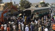 TOPSHOT - Pakistani bystanders watch the rescue work at the site of a collision between two trains in Karachi on November 3, 2016. / AFP / RIZWAN TABASSUM