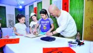 A Chinese artist demonstrates to children the ancient art of woodblock printing at the bazaar.  Pic: Baher Amin / The Peninsula