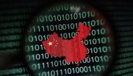 A map of China is seen through a magnifying glass on a computer screen showing binary digits in Singapore. Reuters