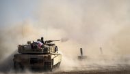Dust rises as a tank from the Iraqi army's 9th armoured division fires at a suspect car approaching their position in the area of Ali Rash, adjacent to the eastern Al-Intissar neighbourhood of Mosul, on November 6, 2016, during a military operation to ret