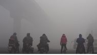 Residents wait for the traffic at an intersection amid heavy smog in Shijiazhuang, Hebei province, China. (Reuters).