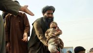 An Afghan man holds up the dead body of a child who was killed by an air strike called in to protect Afghan and U.S. forces during a raid on suspected Taliban militants, in Kunduz, Afghanistan November 3, 2016. REUTERS/Nasir Wakif