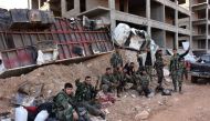 Syrian pro-government forces flash the V-sign as they hold a position in Aleppo's 1070 district on November 8, 2016, after seizing it from rebel fighters. Syrian state media said government forces had advanced southwest of divided second city Aleppo, seiz