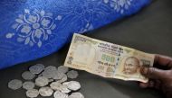 A resident hands a 500 Rupee note to an Indian money lender at his shop in Hyderabad on November 9, 2016, as he seeks to exchange Indian 500 Rupee notes for lesser denominations after the government withdrawal of 500 and 1,000 Indian Rupee notes from fina