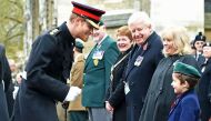 Britain's Prince Harry (L) reacts after shaking hands with a young boy during his visit to the Field of Remembrance at Westminster Abbey in central London on November 10, 2016. AFP / POOL / Eddie Mulholland