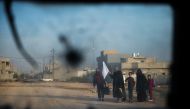 A family holding a white flag looks at a convoy of Iraqi Special Forces' 2nd division driving through the Samah area of Mosul on November 12, 2016. Elite Iraqi forces were engaged in 