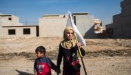 A young girl holding a white flag approaches with her father (unseen) soldiers from the Iraqi Special Forces' 2nd division pushing through the Arbagiah neighbourhood of Mosul as they make their way to their house in the Samah area on November 12, 2016.  A