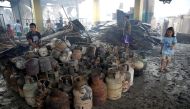 A resident sits near partially burnt LPG cylinders recovered from his family's shop, after a fire in the residential district of Addition Hills in Mandaluyong, Metro Manila, Philippines, November 14, 2016. REUTERS/Erik De Castro